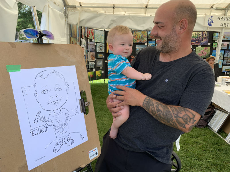 Baby boy getting his caricature drawn
